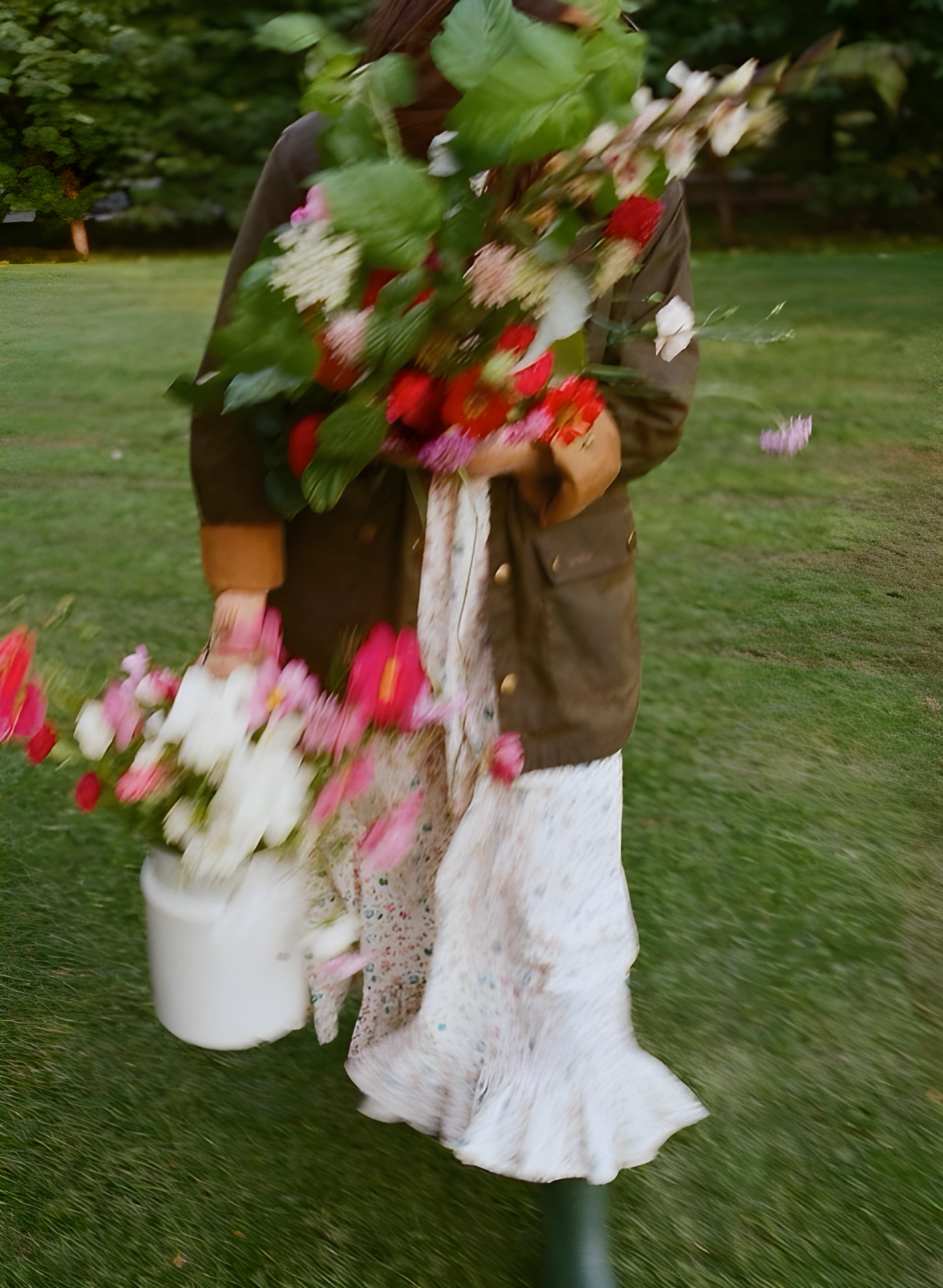 Woman carrying armful of flowers